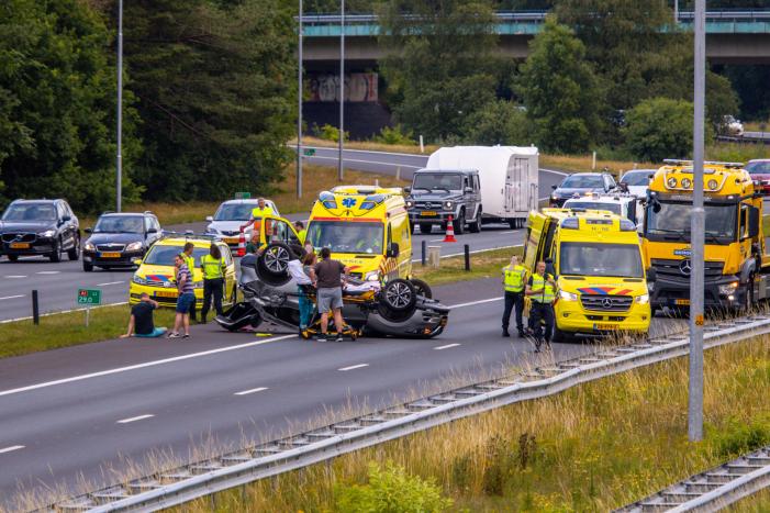 Auto op de kop na aanrijding op snelweg