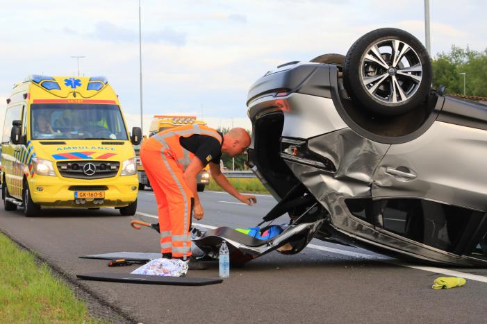 Auto op de kop na aanrijding op snelweg