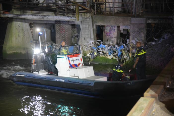 Omstanders halen persoon uit te water geraakte auto