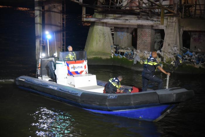 Omstanders halen persoon uit te water geraakte auto