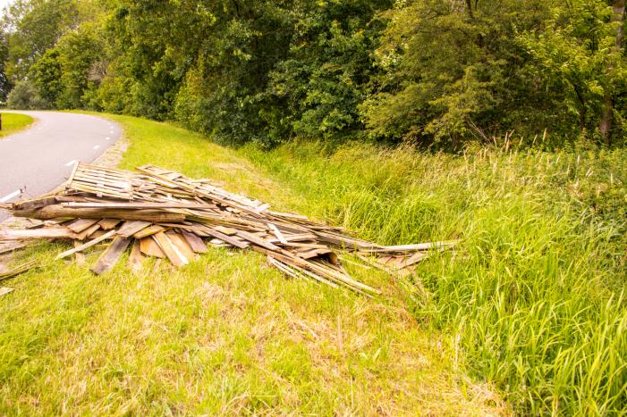 Oude schutting langs de weg gedumpt