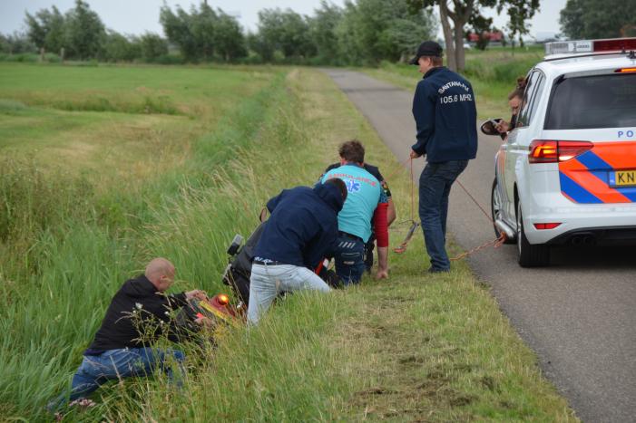 Omstanders halen scootmobiel uit greppel