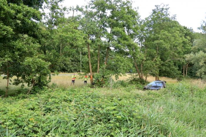 Auto crasht tussen bomen door