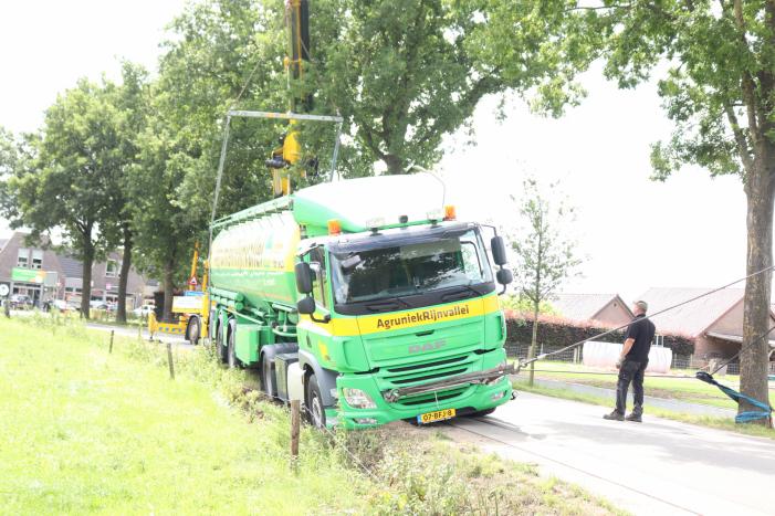 Vrachtwagen met bulkoplegger zakt weg in berm