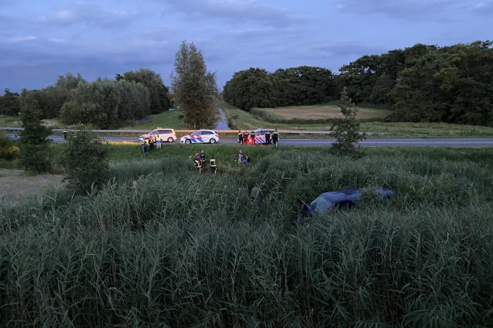 Bestelbus vliegt over de vangrail belandt in riet