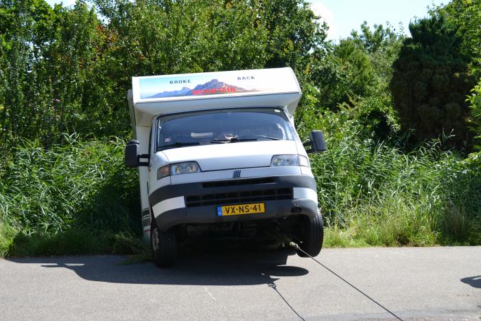 Camper rijdt achteruit de sloot in