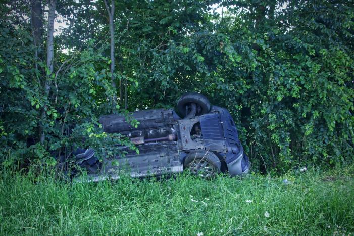 Auto slaat over de kop de berm in