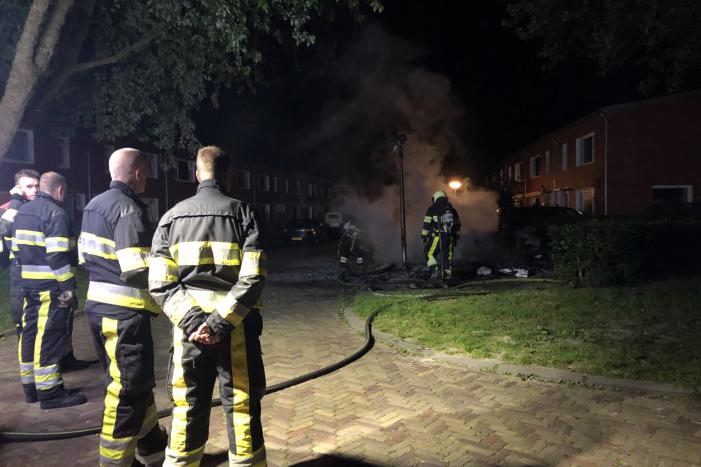 Stapel grofvuil laat lantaarnpaal branden