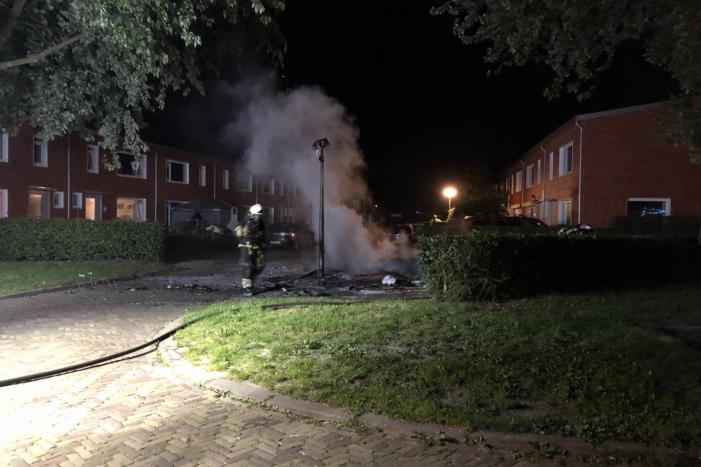 Stapel grofvuil laat lantaarnpaal branden