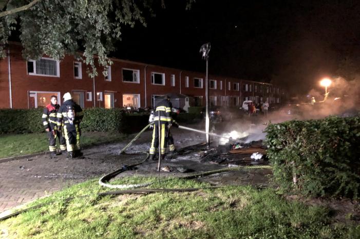 Stapel grofvuil laat lantaarnpaal branden