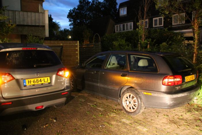 Auto botst op twee geparkeerde auto's en belandt in achtertuin