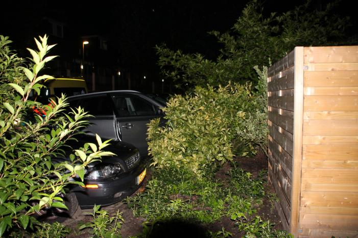 Auto botst op twee geparkeerde auto's en belandt in achtertuin