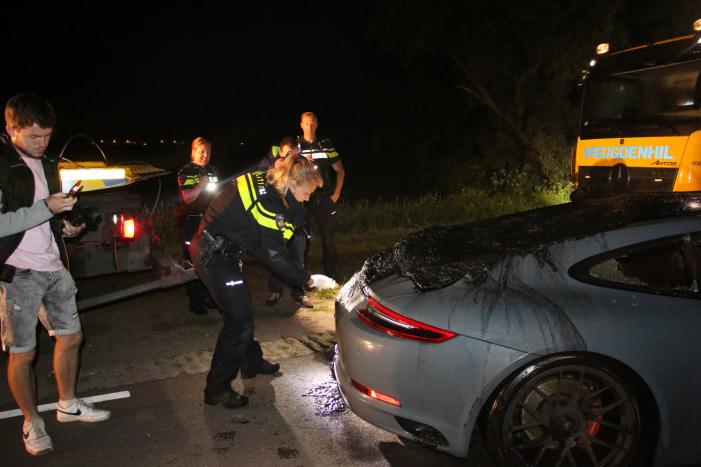 Peperdure Porsche belandt in de vaart na ontwijken van een dier