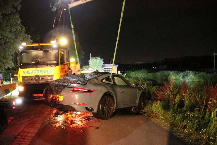 Peperdure Porsche belandt in de vaart na ontwijken van een dier