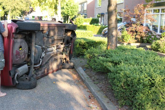 Bestuurder raakt onwel, botst op geparkeerde auto en belandt op zijn kant