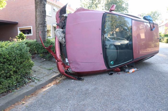 Bestuurder raakt onwel, botst op geparkeerde auto en belandt op zijn kant
