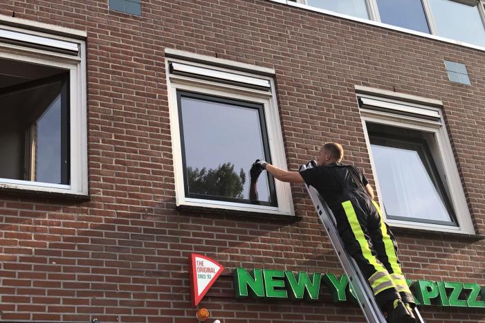 Kat vast tussen klapraam