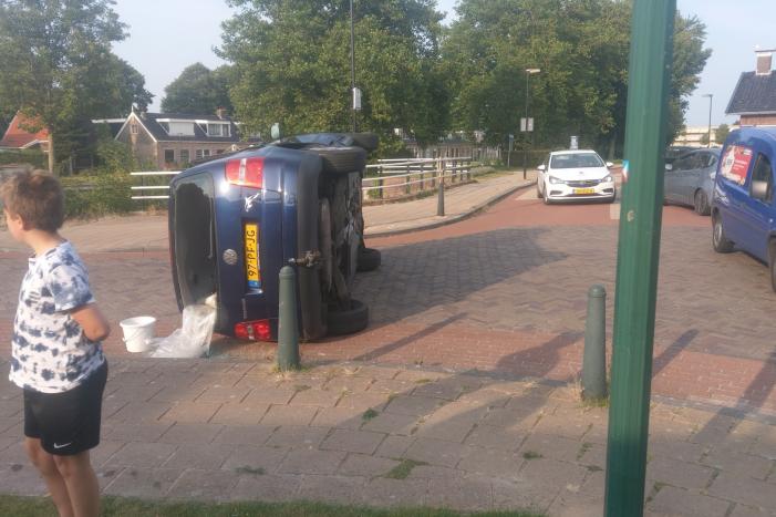 Auto op zijn kant na verkeersongeval