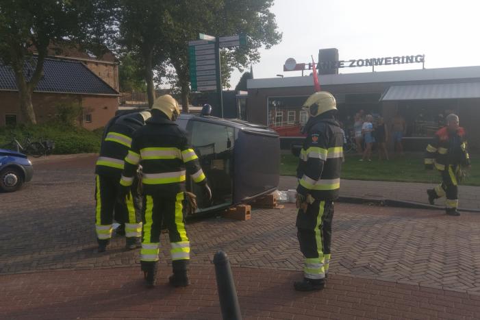 Auto op zijn kant na verkeersongeval