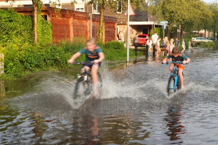 Jeugd vermaakt zich in ondergelopen straat