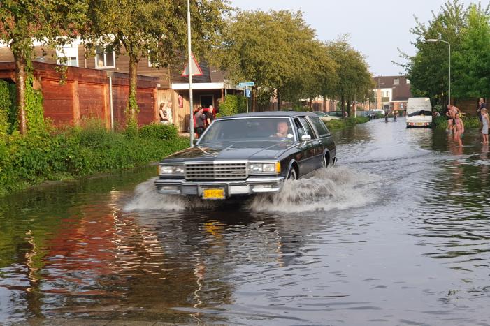 Jeugd vermaakt zich in ondergelopen straat