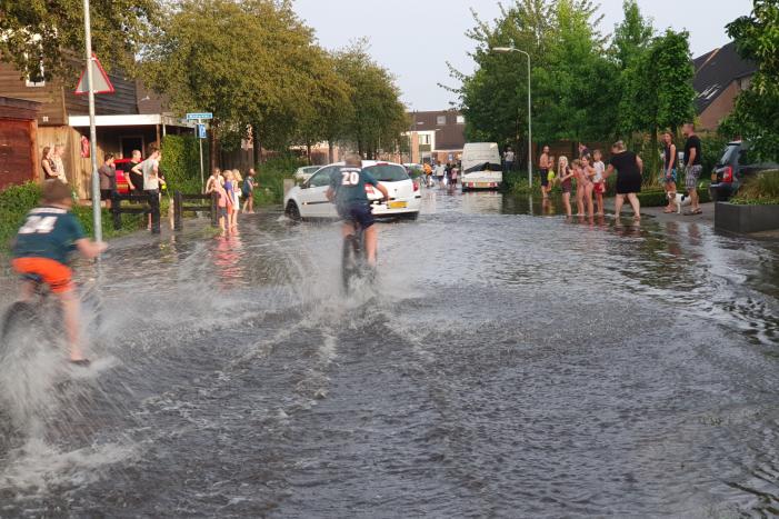 Jeugd vermaakt zich in ondergelopen straat