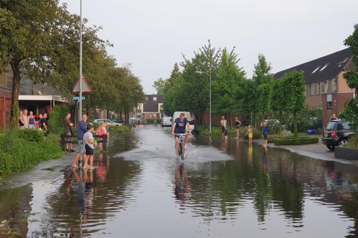 Jeugd vermaakt zich in ondergelopen straat