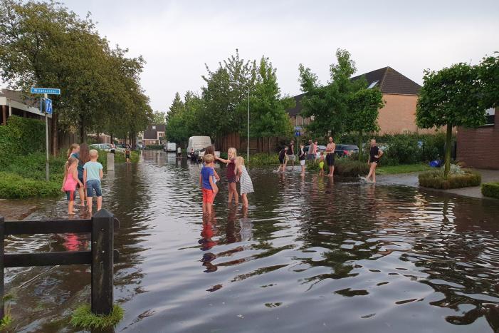 Jeugd vermaakt zich in ondergelopen straat