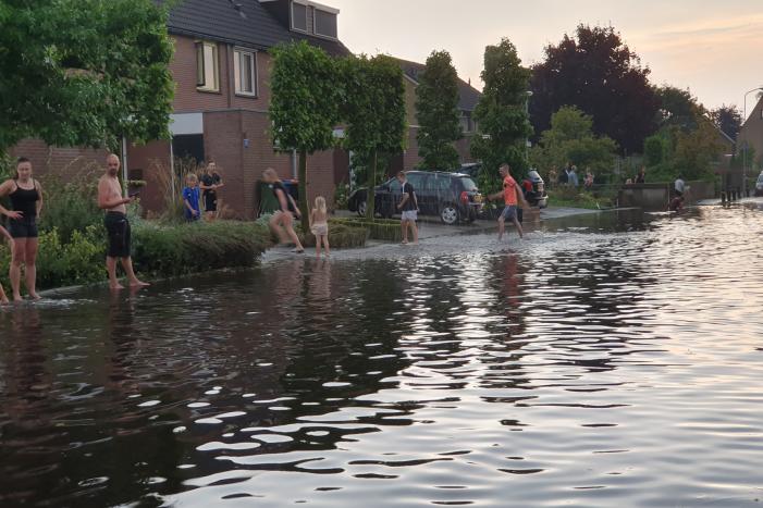 Jeugd vermaakt zich in ondergelopen straat