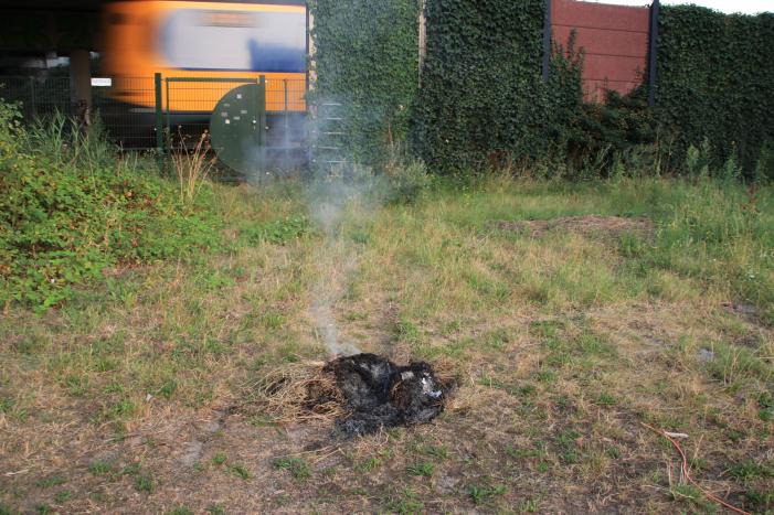 Buurtbewoner blust een hoop in brand gevlogen hooi