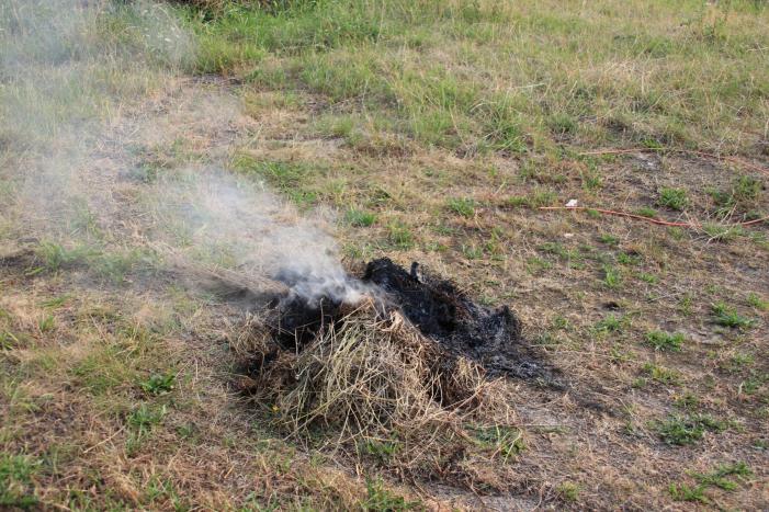 Buurtbewoner blust een hoop in brand gevlogen hooi