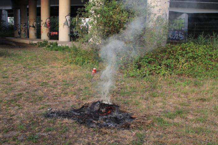 Buurtbewoner blust een hoop in brand gevlogen hooi