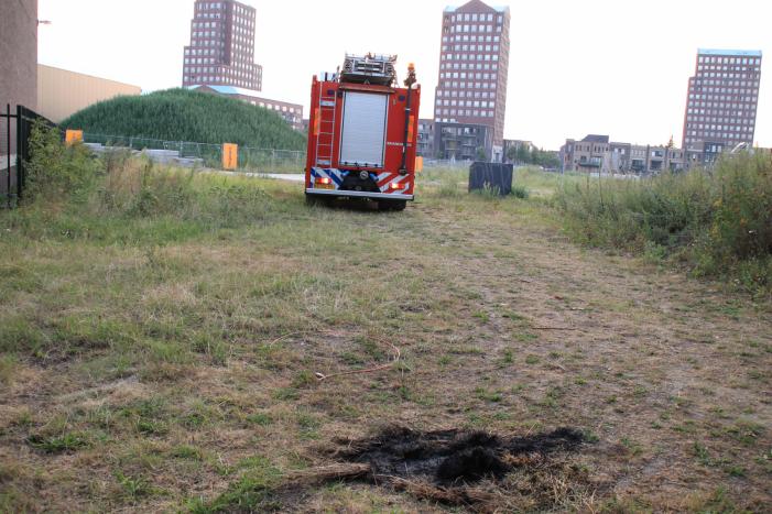 Buurtbewoner blust een hoop in brand gevlogen hooi
