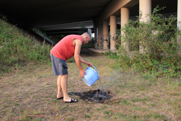 Buurtbewoner blust een hoop in brand gevlogen hooi
