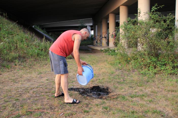 Buurtbewoner blust een hoop in brand gevlogen hooi