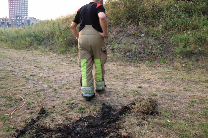 Buurtbewoner blust een hoop in brand gevlogen hooi