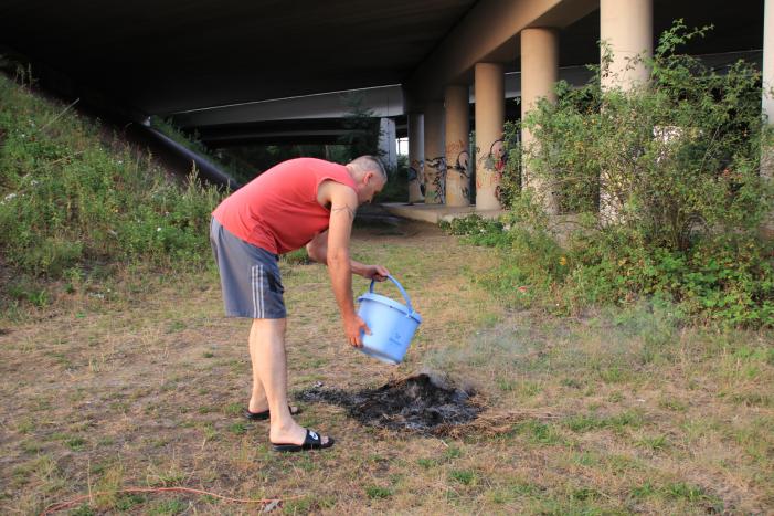 Buurtbewoner blust een hoop in brand gevlogen hooi