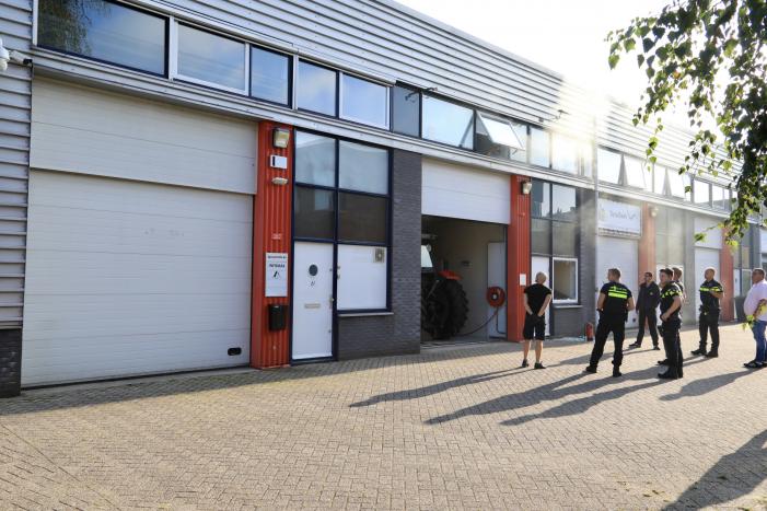 Medewerkers blussen brand in bedrijfsverzamelgebouw