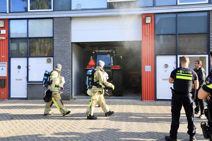 Medewerkers blussen brand in bedrijfsverzamelgebouw