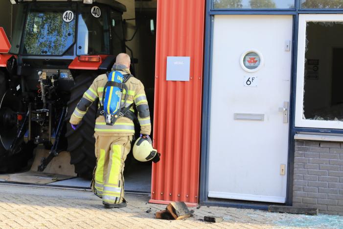 Medewerkers blussen brand in bedrijfsverzamelgebouw