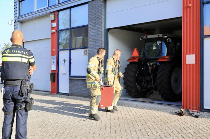 Medewerkers blussen brand in bedrijfsverzamelgebouw