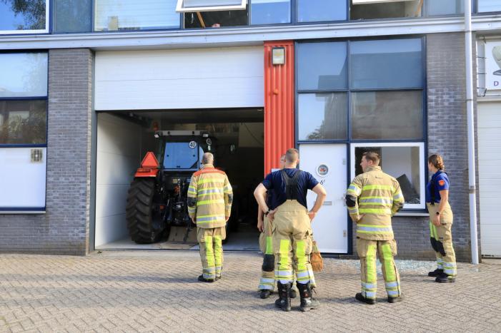 Medewerkers blussen brand in bedrijfsverzamelgebouw
