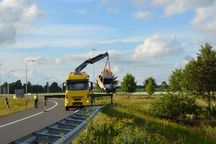 Auto belandt naast de snelweg en vliegt in brand