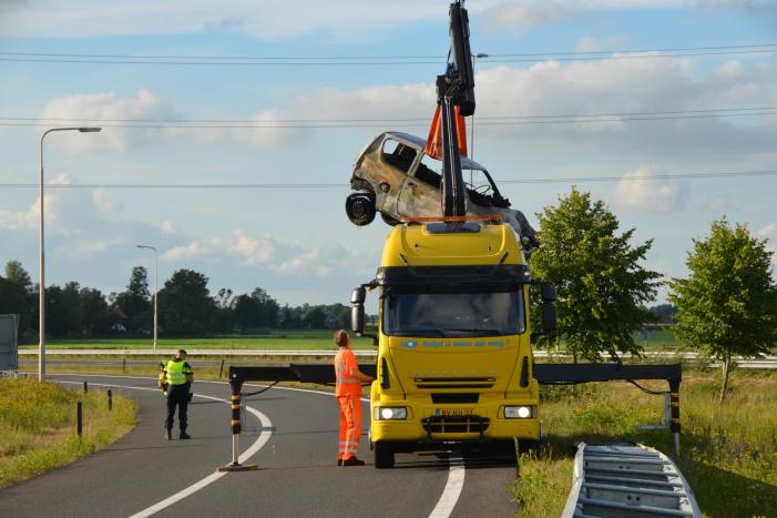 Auto belandt naast de snelweg en vliegt in brand