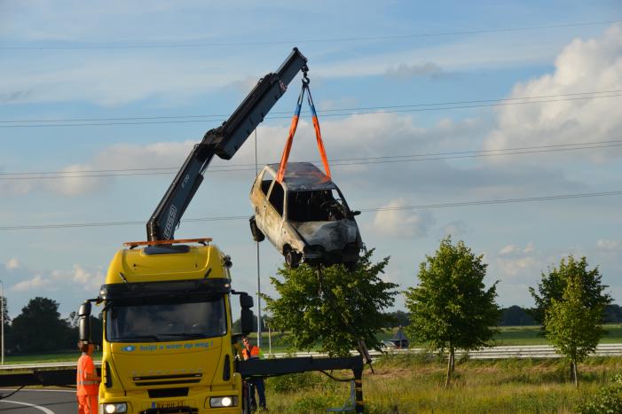 Auto belandt naast de snelweg en vliegt in brand
