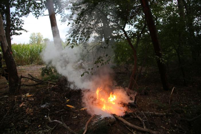 Berg afval in bos in brand gestoken