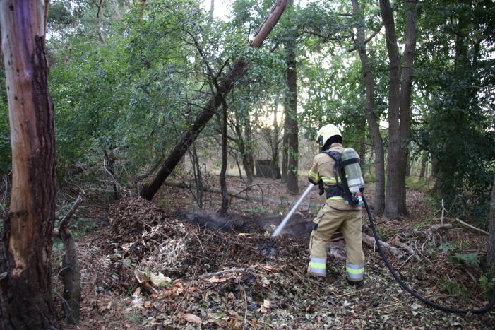 Berg afval in bos in brand gestoken