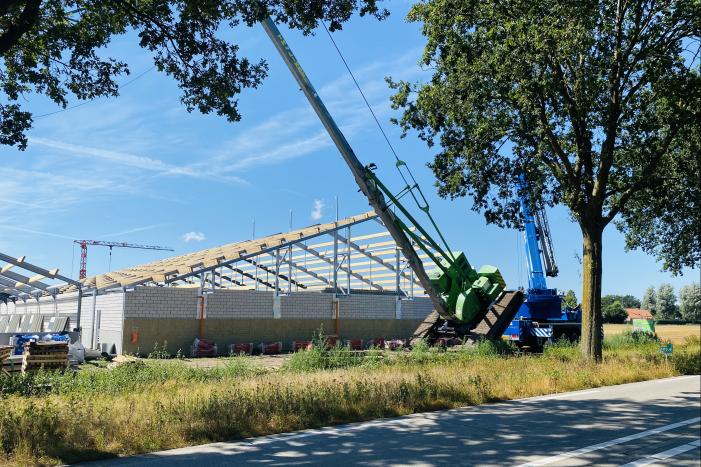 Bouwkraan achter stal omgevallen