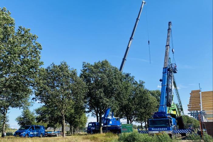 Bouwkraan achter stal omgevallen