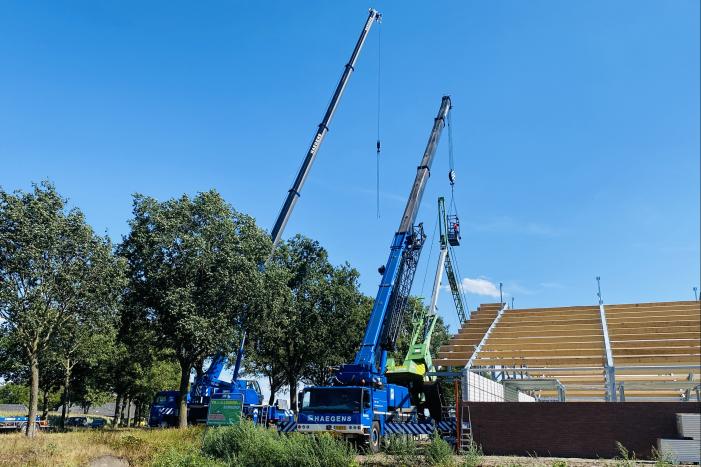 Bouwkraan achter stal omgevallen